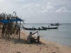 Ein Fischer holt sein Netz vom Strand aus ein